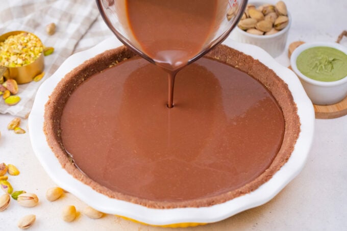 Topping Dubai chocolate tart with chocolate ganache.