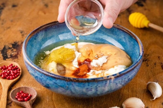 Combining honey mustard sauce ingredients in a bowl.