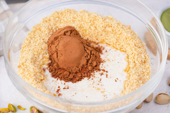 Graham cracker crumbs, butter, sugar, and cocoa powder in a bowl.