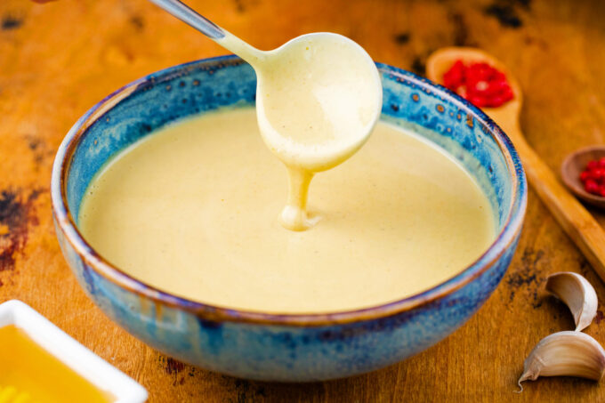Honey mustard sauce dripping of a spoon.