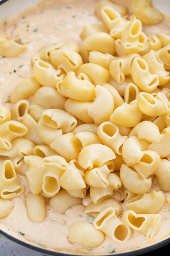 Adding pasta to shrimp mac and cheese.