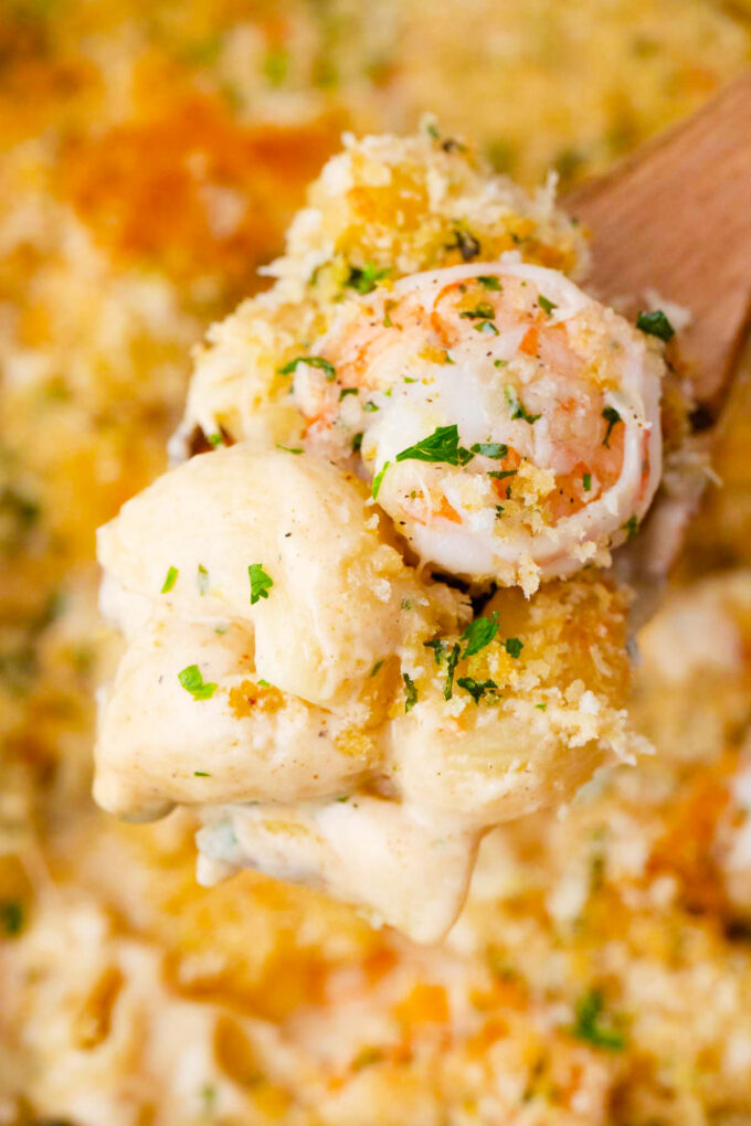 A serving spoon of cheesy shrimp mac and cheese.