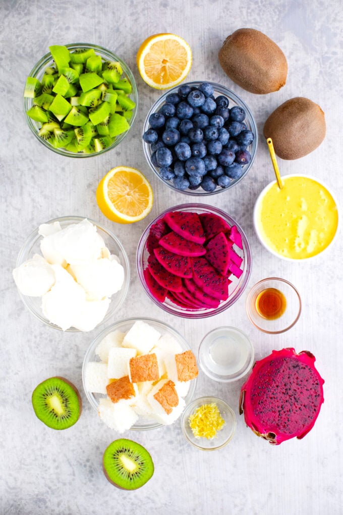 Overhead shot of Mardi Gras trifle ingredients arranged on a light surface.