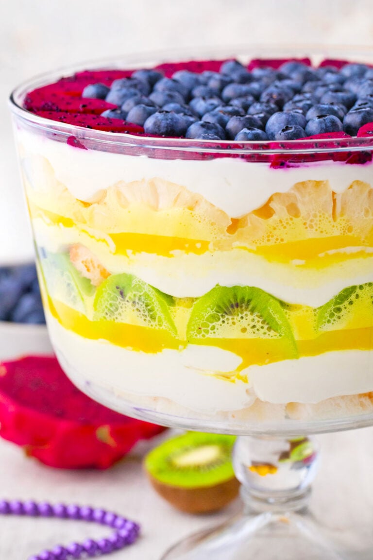 Mardi Gras trifle with layers of frosting, lemon curd, kiwi, pineapple, berries, and angel food cake.
