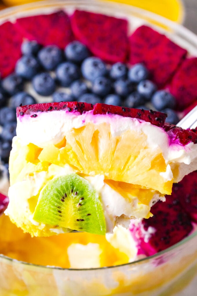 A spoonful of Mardi Gras trifle with kiwi, pineapple, and dragon fruit.