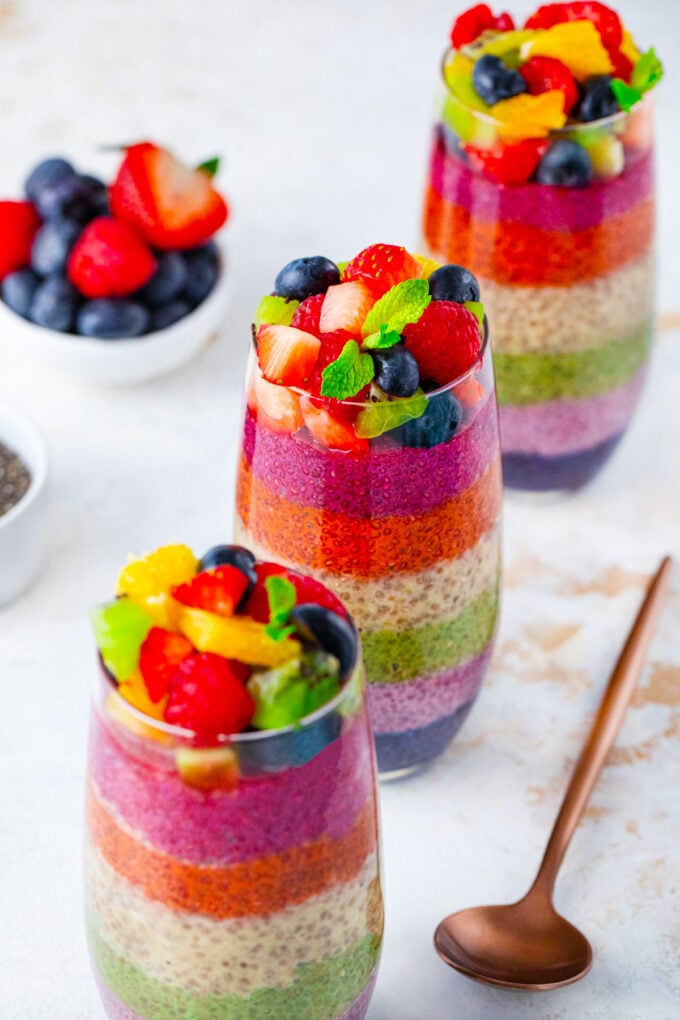 Rainbow chia pudding parfaits topped with fresh fruit and mint.