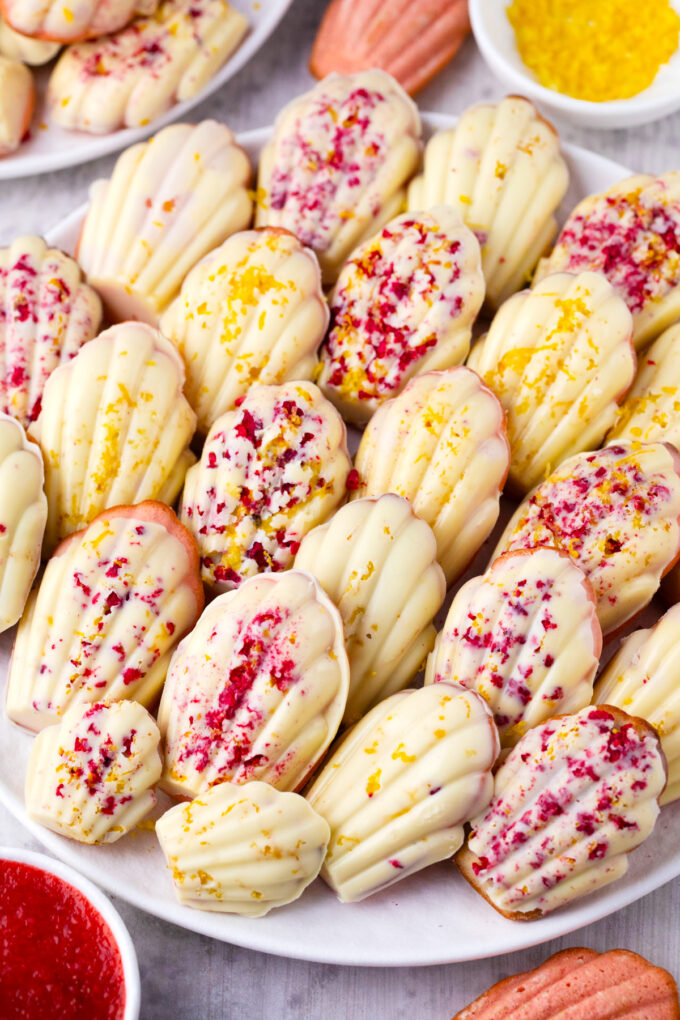 A tray of strawberry madeleines with white chocolate, freeze dried strawberries and lemon zest.