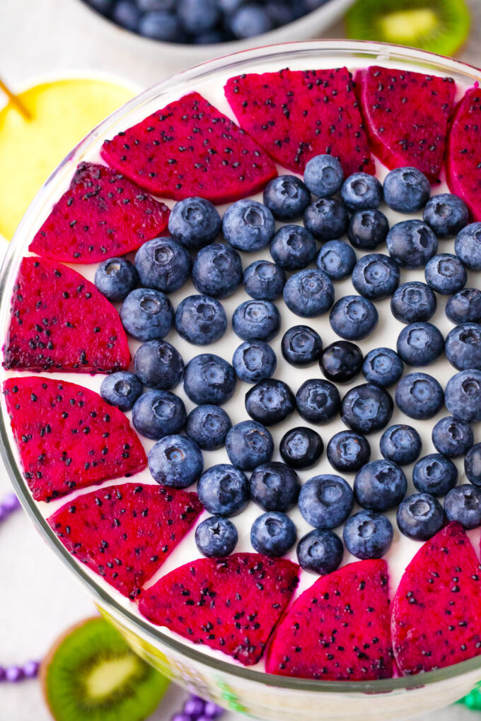 Mardi Gras trifle topped with sliced dragon fruit and blueberries.