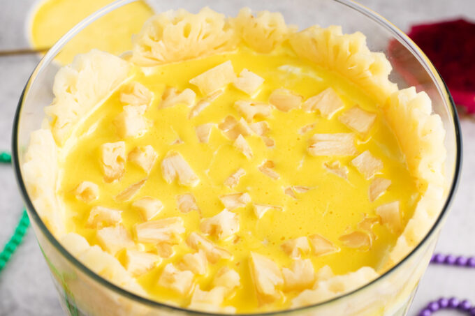 Adding a layer of lemon curd and pineapple to Mardi Gras trifle.