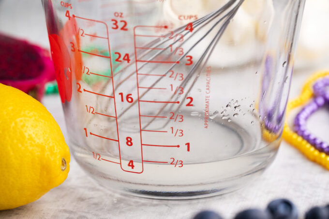 Whisking lemon simple syrup in a cup.