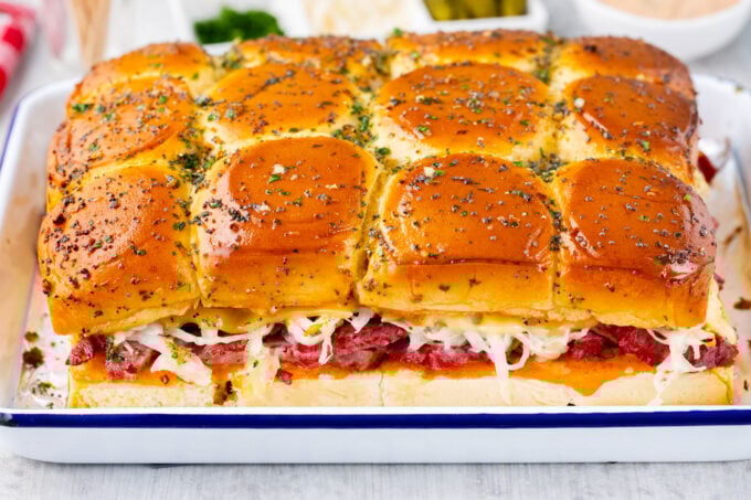 Homemade corned beef sliders topped with garlic sauce.