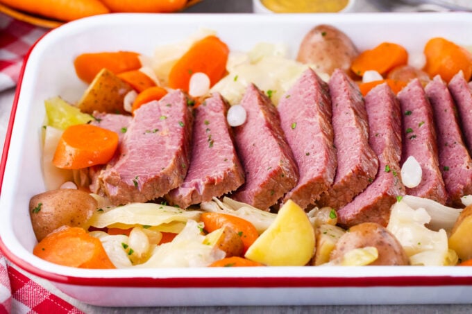 Sliced Dutch oven corned beef with cabbage, carrots, and potatoes.