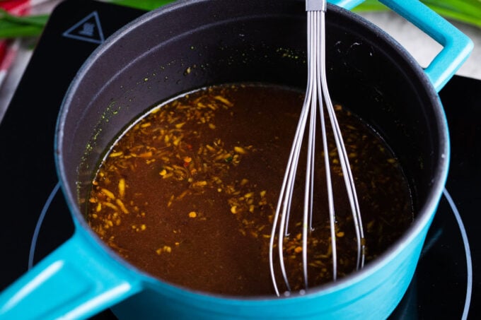 Whisking General Tso sauce in a saucepan.