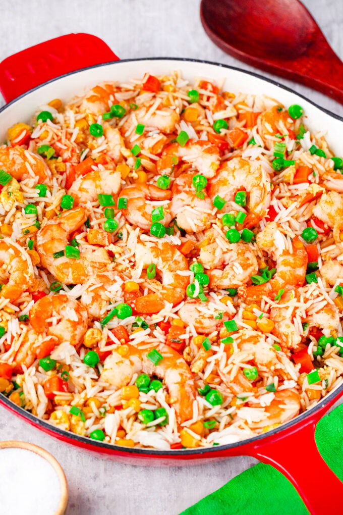 A pan of homemade shrimp fried rice with green peas and corn.