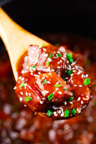 A serving spoon of slow cooker honey sesame chicken.
