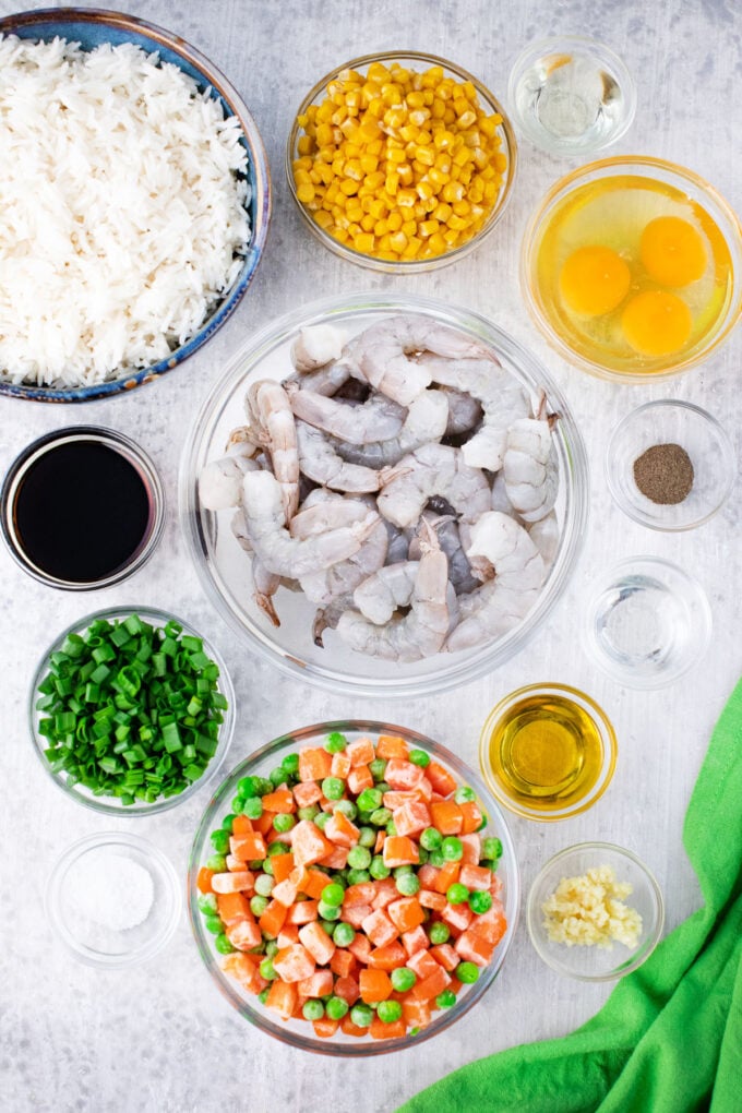 Overhead shot of shrimp fried rice recipe ingredients arranged in bowls.