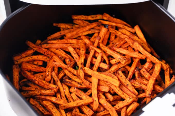 Air fried sweet potato fries in the air fryer basket.