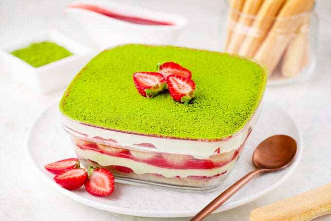 Matcha strawberry tiramisu with strawberry sauce and fresh strawberries.