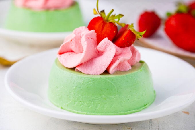 Homemade matcha panna cotta with strawberry whipped cream.